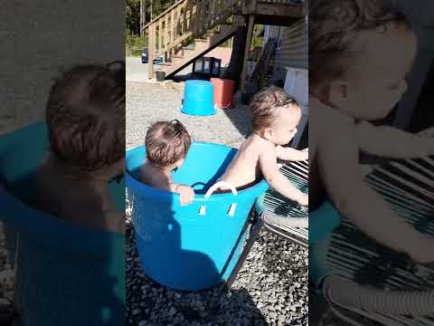 Beautiful twins boys bathing in a tub with nature.