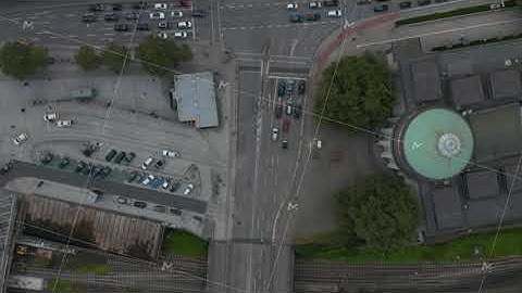 Aerial birds eye overhead top down view of multilane road leading between buildings and across