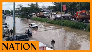 Vehicles wade through a flooded section of Kitengela town