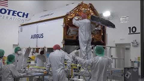 Technicians install multi-layer insulation on the Sentinel-6B spacecraft on a work stand inside 