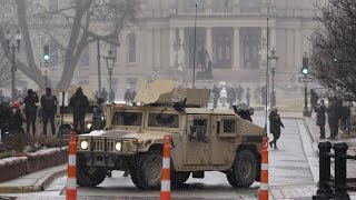 Small group of armed protesters dwarfed by police at Michigan Capitol