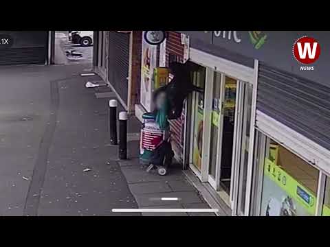 Woman left dangling in mid air after being lifted off her feet by shop shutters