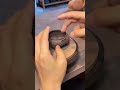 Potter shaping textured clay pot on turning wheel.
