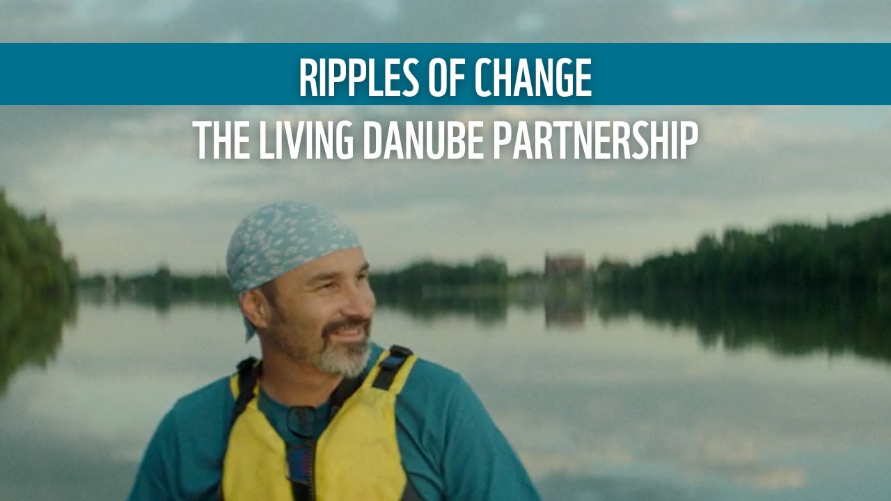 Man standing in front of a body of water. Text: Ripples of Change The Living Danube Partnership