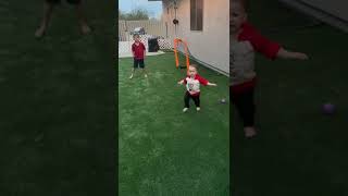 Boy kicks soccer ball and accidentally hits his little brother on heard