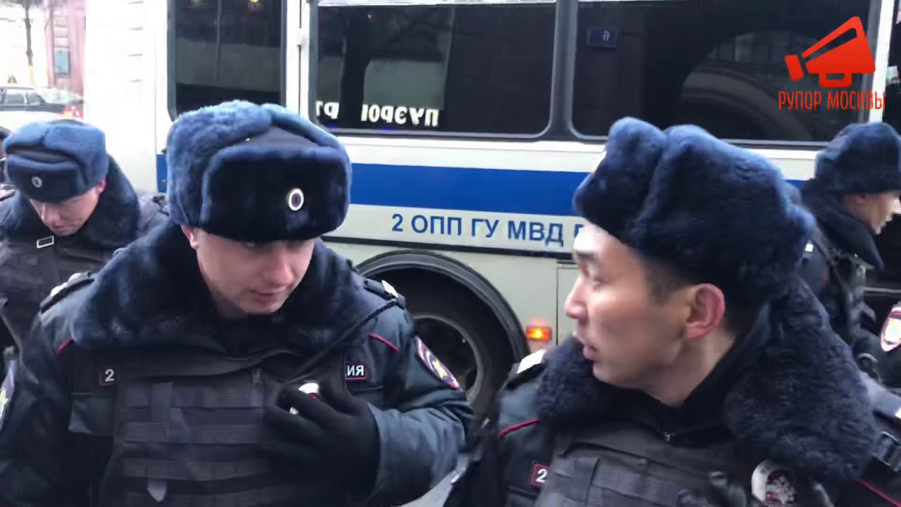 Полицейский прячет нагрудный знак во время задержаний.Москва 28.10.18