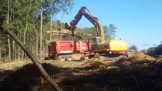 Deere 270C LC Loading A Kenworth W900L With Brush