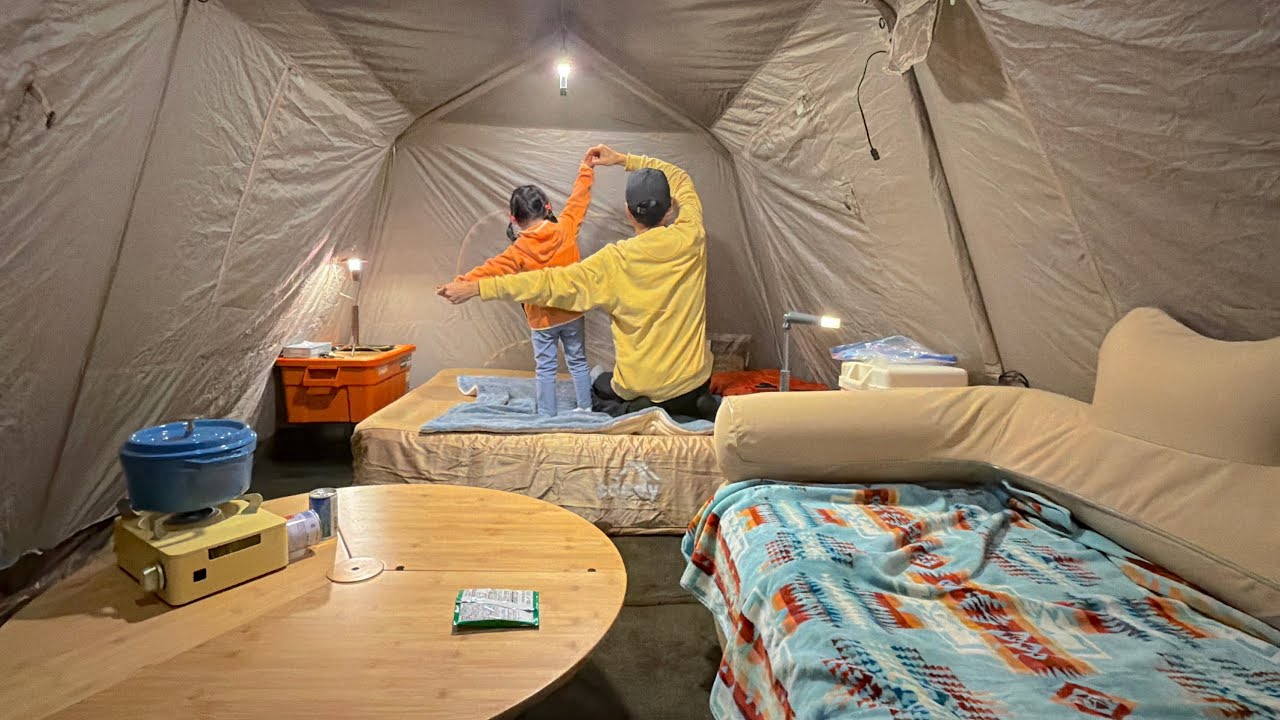 Отец и дочь в походе. Внутри палатки находится маленький домик.