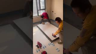 the process of installing large ceramic tiles on the top floor of a multi-storey building #popular