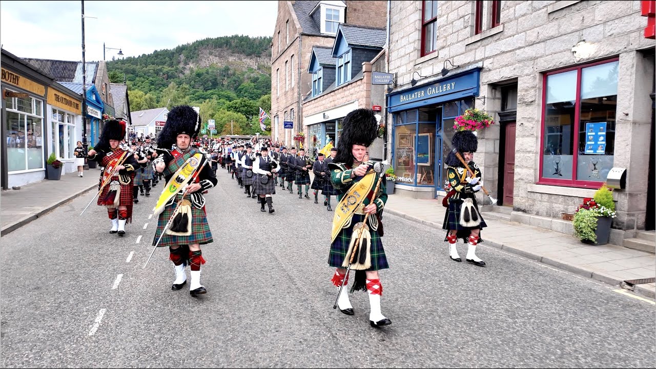 Drum Majors lead Pipe Bands playing Lochanside on march after 2024 Ballater Highland Games Scotland