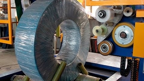 Coil wrapping machine with stretch film and woven