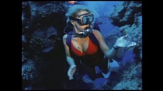Woman scuba diving deep reef 1980s