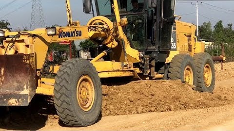 Motor Grader Grading Next To The TrainStation Skilled Operator And Roller Working