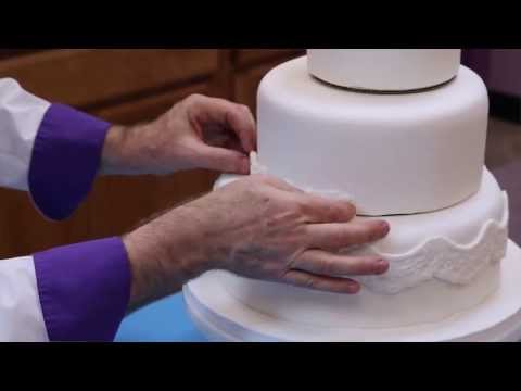 http://globalsugarart.com Chef Alan Tetreault of Global Sugar Art shows you how to make your own fondant covered wedding cake. Learn how to cut, fill and ice the cake, cover with rolled fondant,...