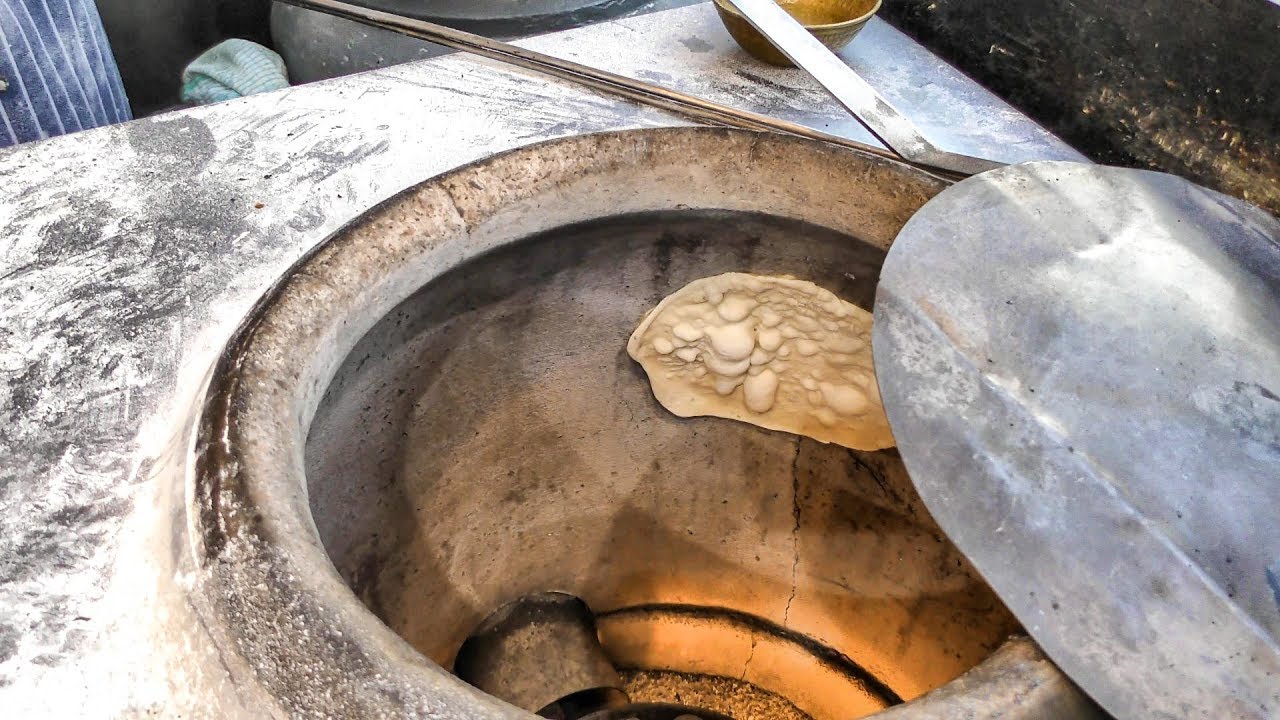 Naan Indian Bread Hand Made and Cooked in a Clay Oven in Old Spiltafields  Market, London 