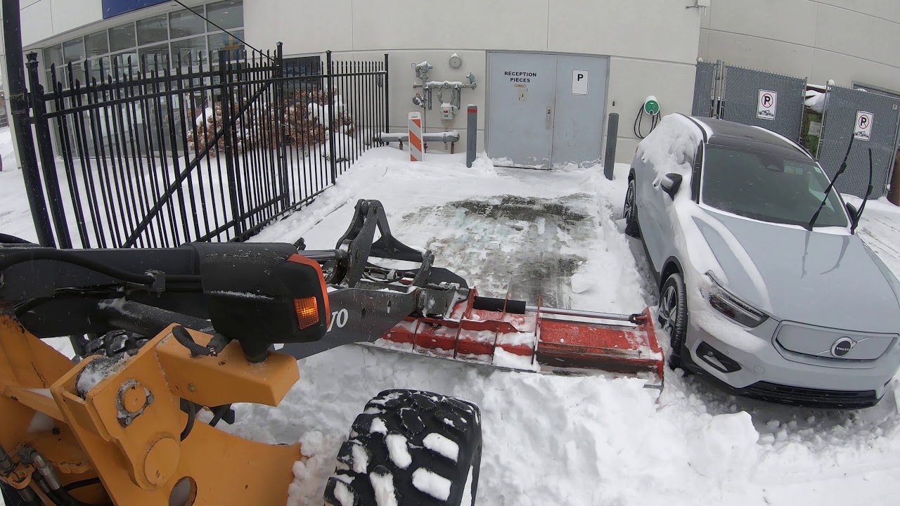 Volvo L20B plowing snow with extendable reversible plow