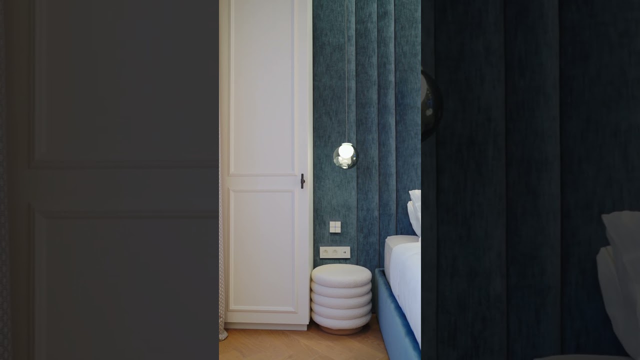 Interieurvideo met donkerblauw maatwerk, wandlicht en zachte materialen in de slaapkamer