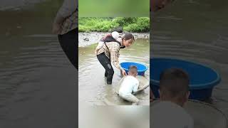 A single mother catches fish with her two young children to sell in order to make ends meet.