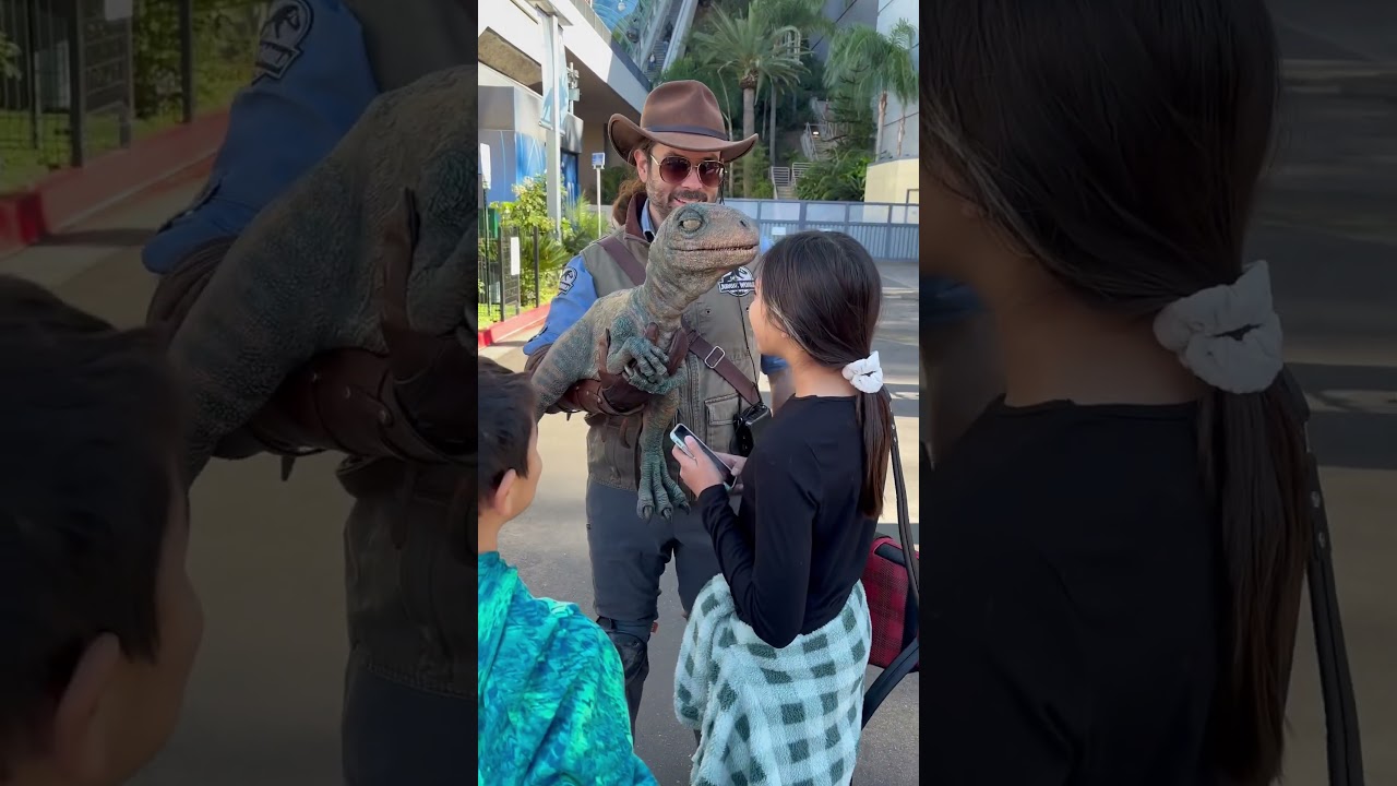 Fans take a picture with a baby velociraptor! 