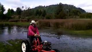 mini tractor estacando el borde de la laguna