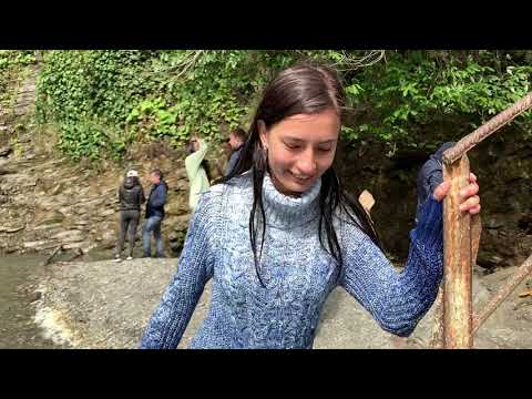 Dasha bathes in jeans and a sweater in a waterfall