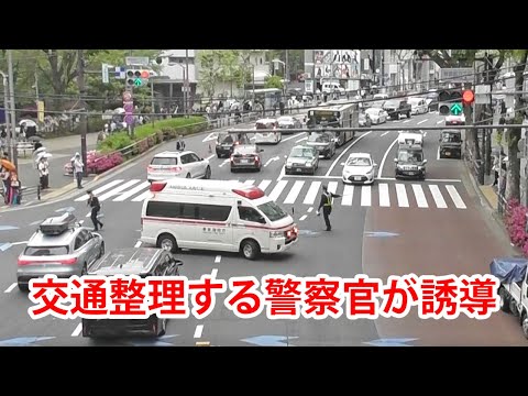 交通整理する警察官が誘導し緊急走行する救急車！