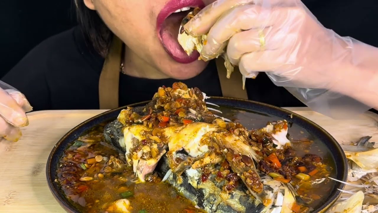 Eating steamed big fish head with soy been sauce