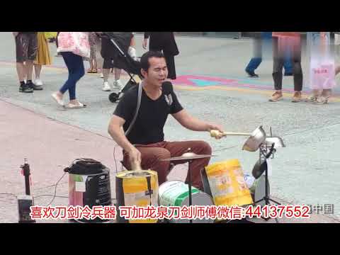 北京长安街沿线上，街头歌手用垃圾桶当乐器，唱完很多人捐钱