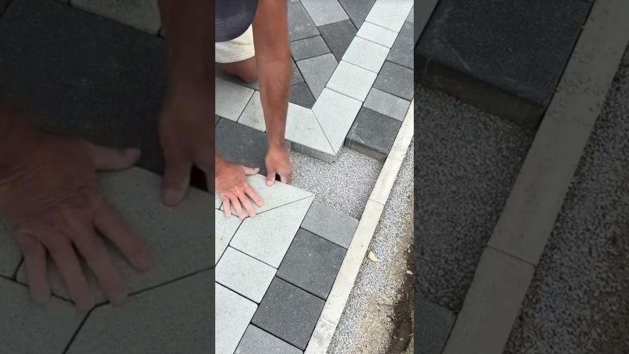 the process of installing black and white bricks on the floor of a large yard 