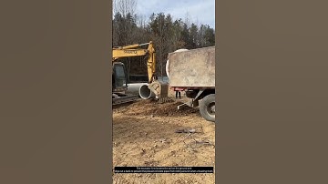 The excavator is unloading precast concrete pipes