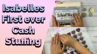 Isabelle cash stuffing $5, learning to budget