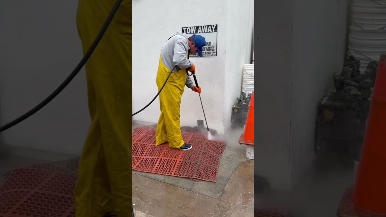 Commercial Cleaning of San Diego technician hot-water cleaning a greasy commercial kitchen floor mat