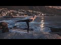 Slow Motion Footage Of A Woman Doing Yoga Outdoors With The View Of A Village By Sea
