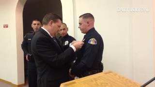 Father pins badge on his son after he is sworn in as a Ukiah Police officer.