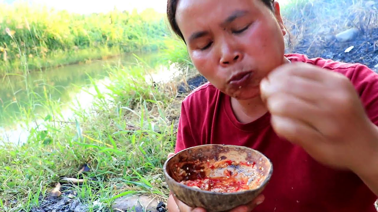 survival in the rainforest - woman cooking ell with winged bean in clay ...