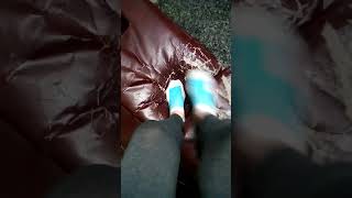 Ankle socks and bare feet stomping on leather couch