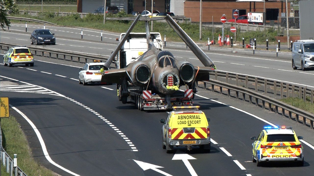 Police escort military aircraft as traffic stops for wide load; Blackburn Buccaneer attack plane
