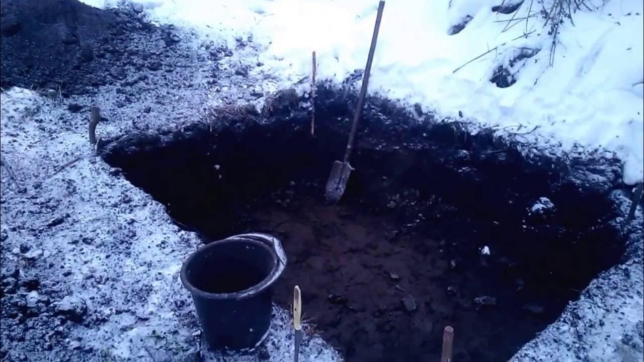 Сколько стоит выкопать туалет. Вырытая яма. Копка ямы зимой. Копает яму зимой. Вырытая круглая яма.