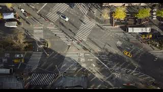 Aerial birds eye overhead top down ascending footage of pedestrians crossing street on large