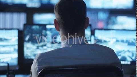 Security Officer is Working on Computer in a Dark Monitoring Room Filled | VideoHive 14760097
