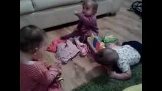 One year old triplets playing and fighting