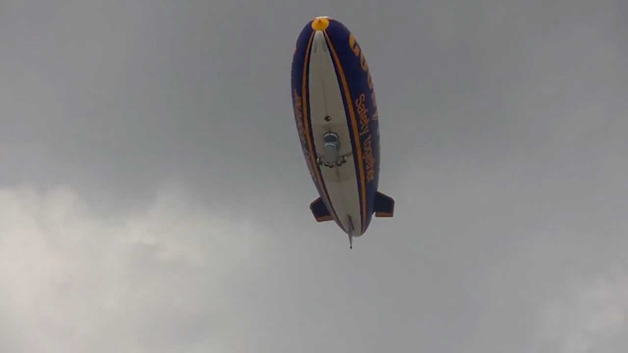 Goodyear blimp flying over London Bridge.