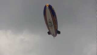 Goodyear blimp flying over London Bridge.
