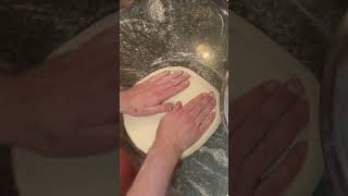 Stretching a perfectly round pizza dough!