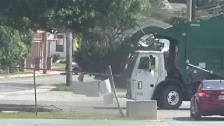 Waste Management Garbage Truck With The Front Loader Lifting The Dumpster
