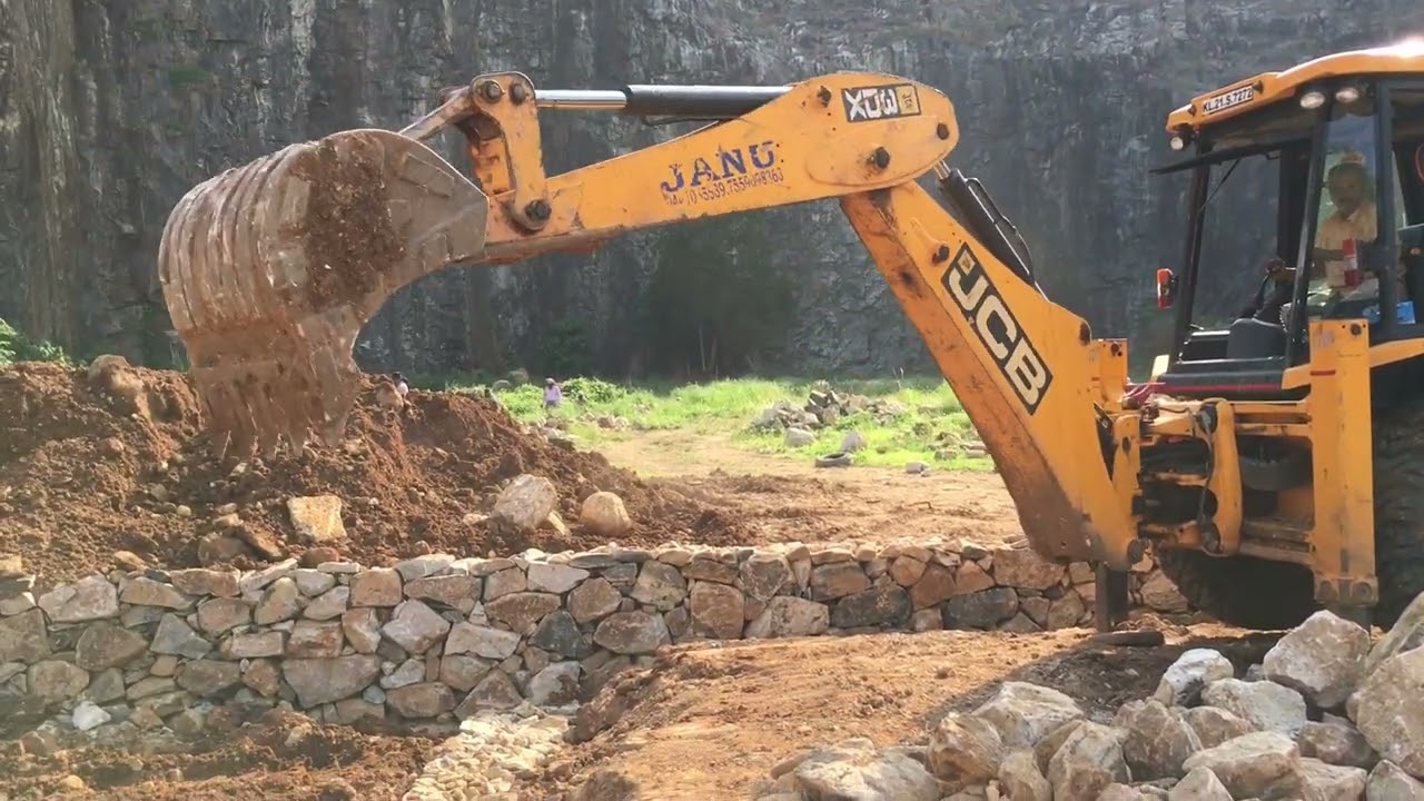 jcb 3dx moving rock pieces to one side