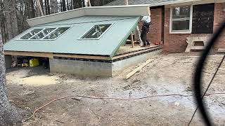 Lifting a rake wall with siding and windows installed.