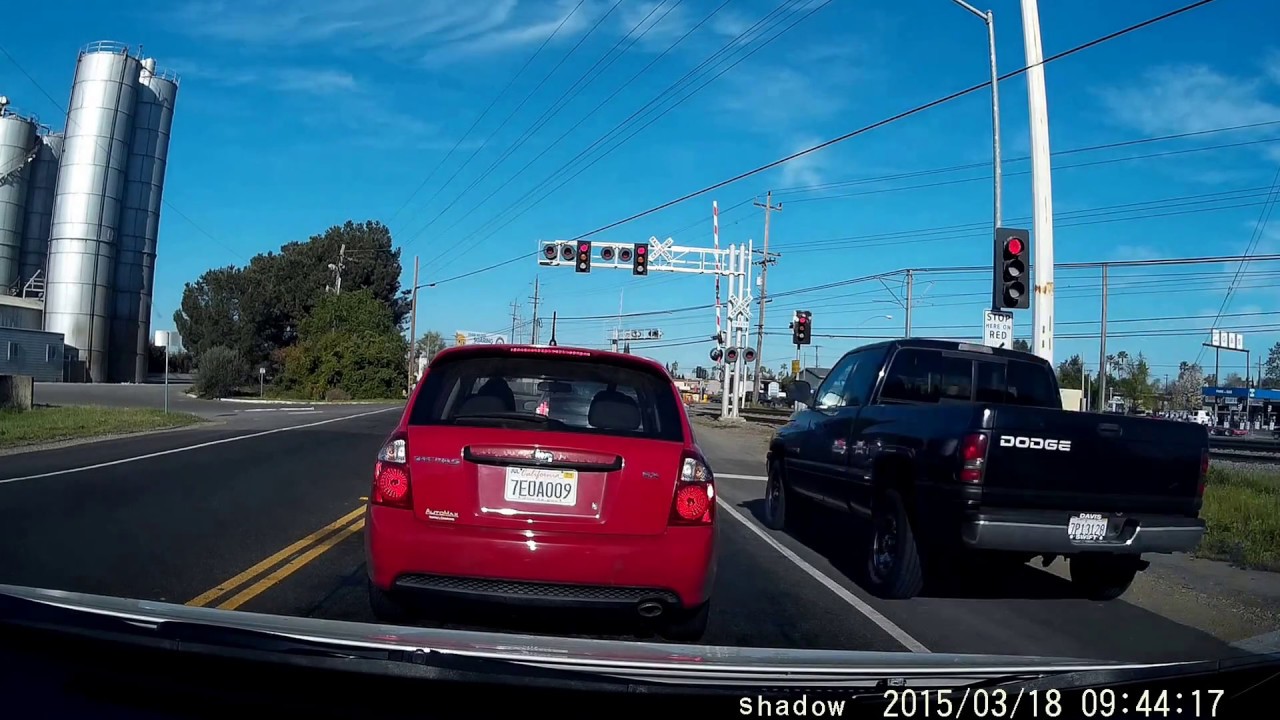 Truck drives on shoulder and blows through red light across train ...