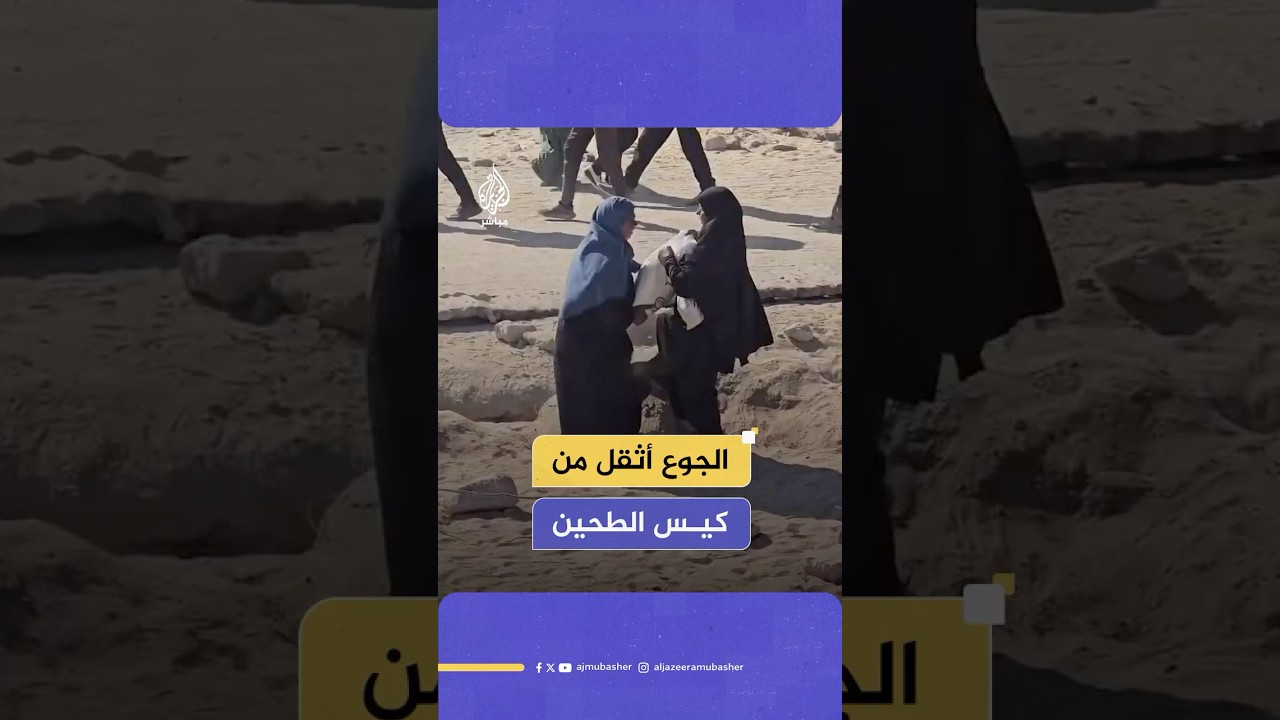 فلسطينيتان تتناوبان على حمل كيس طحين بعد الحصول عليه من منطقة توزيع المساعدات شمال غربي مدينة غزة
