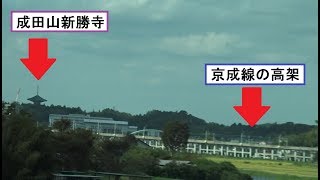 成田空港に向かう京成本線の高架橋と成田山新勝寺が見える東関東自動車道からの車窓